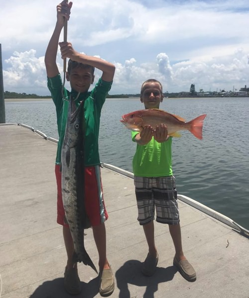 Kids with fish they caught on a Kids Special fishing charter with On The Hook Charters in Daytona Beach
